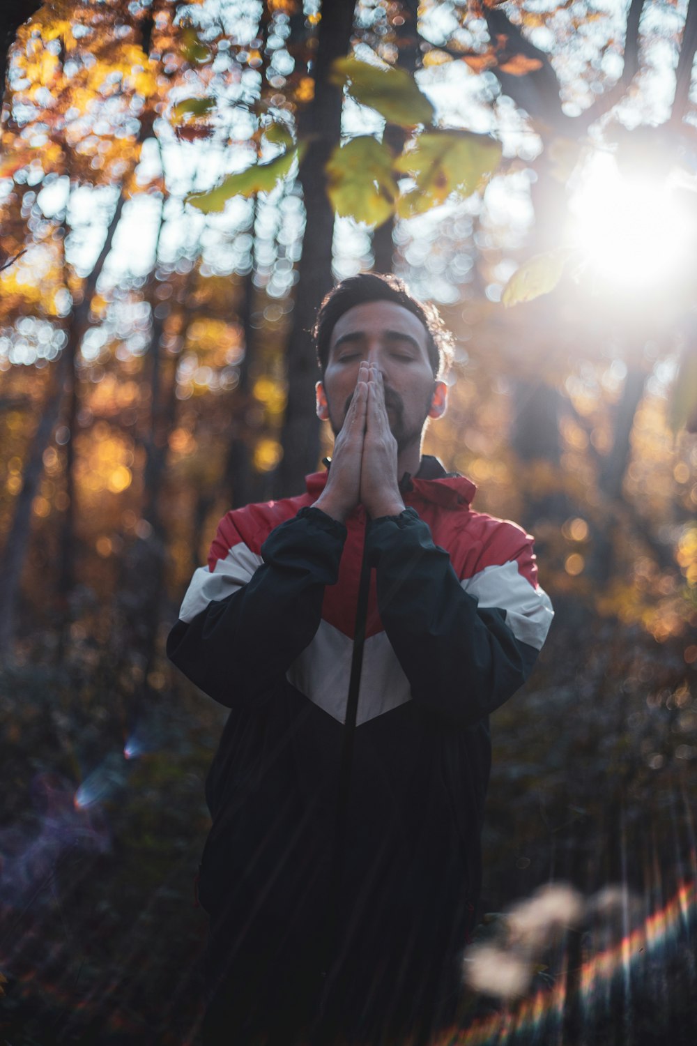 shallow focus photo of man in black, white, and red full-zip hoodie