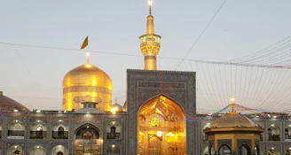 A serene golden-lit view of Masjidil Aqsa at dusk with intricate architectural details.
