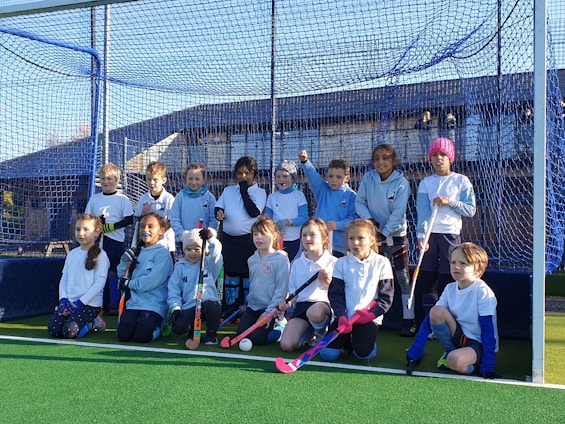 A vibrant group of children and volunteers playing sports together in a sunny Asansol park.