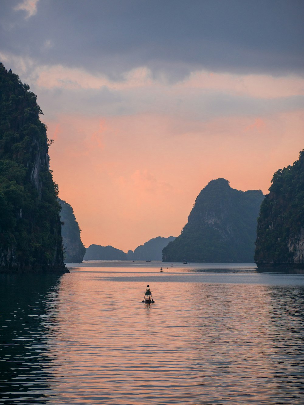 view photography of sea and island under cloudy sky