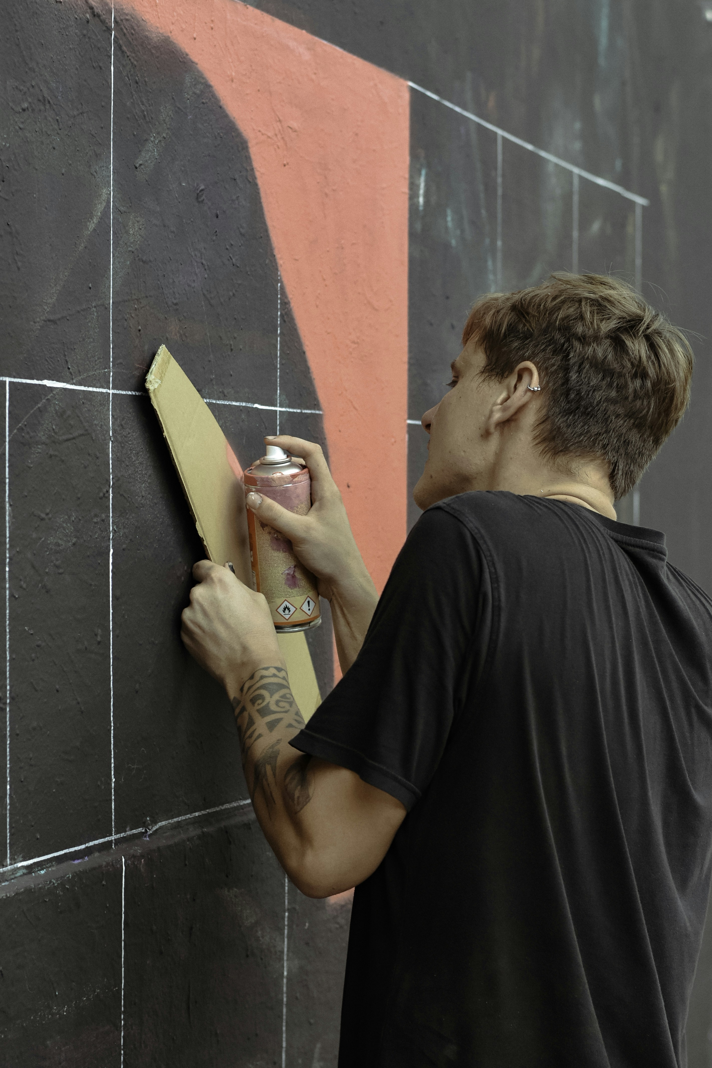 man in black T-shirt using spray can