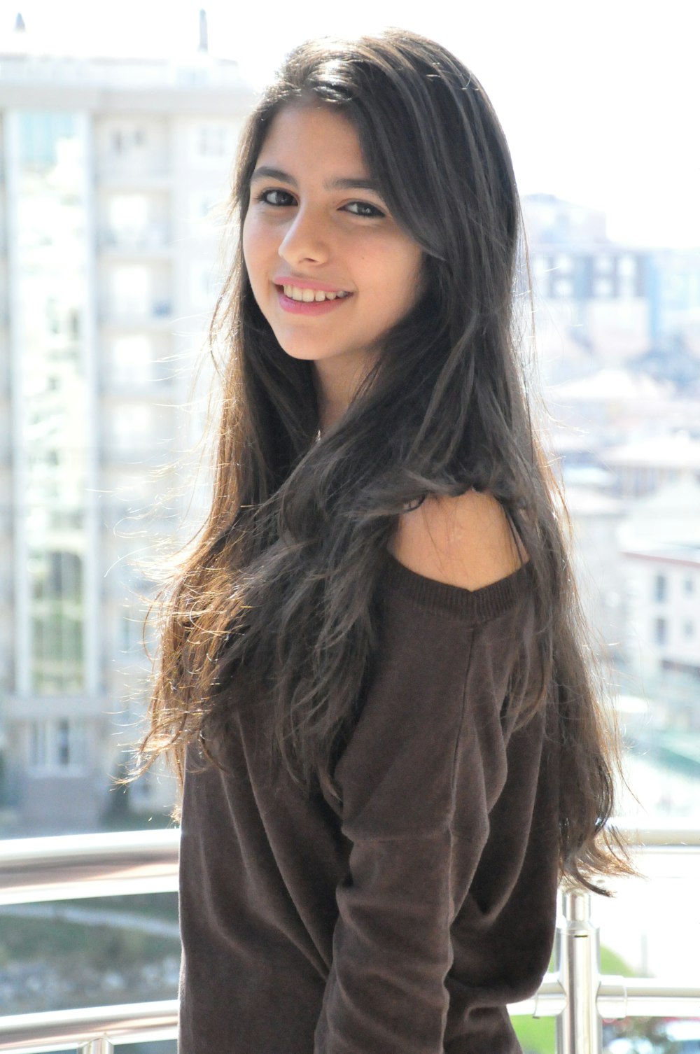 smiling woman standing near buildings during daytime