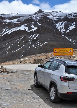 silver SUV park near mountain during daytime