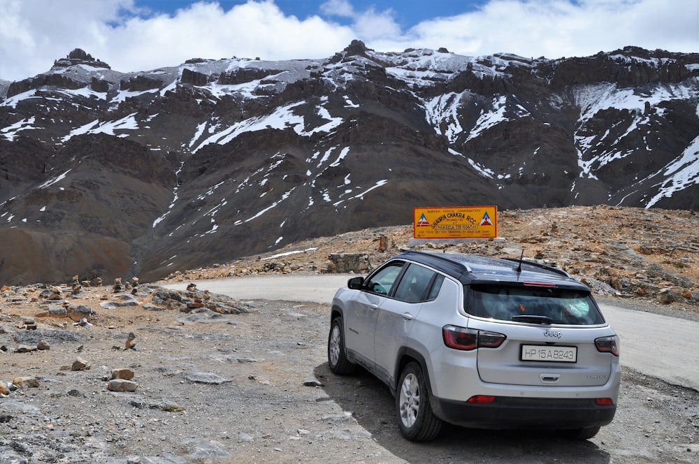 silver SUV park near mountain during daytime