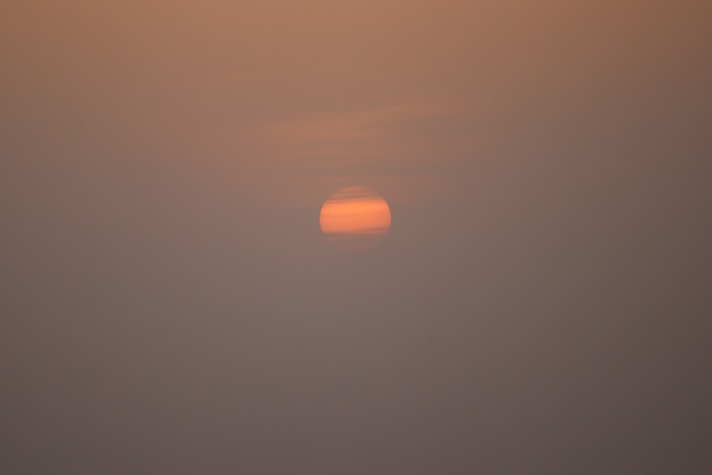 the sun is setting in a hazy sky