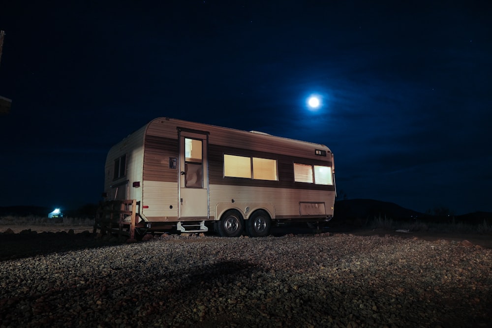 Remolque camper blanco y gris en el campo durante la noche