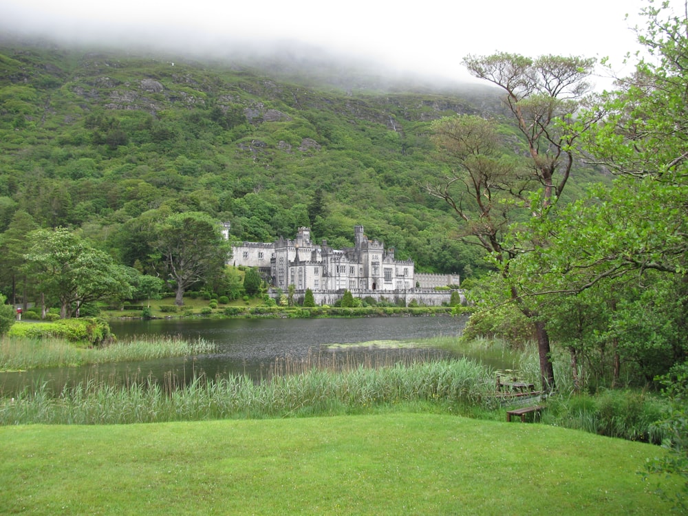 white building near mountain and body of water