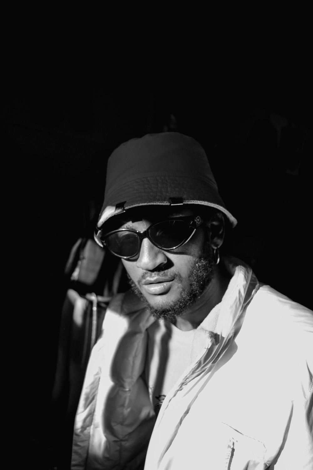 grayscale photo of man wearing bucket hat and jacket