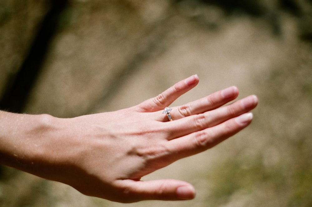 person wearing silver-colored ring
