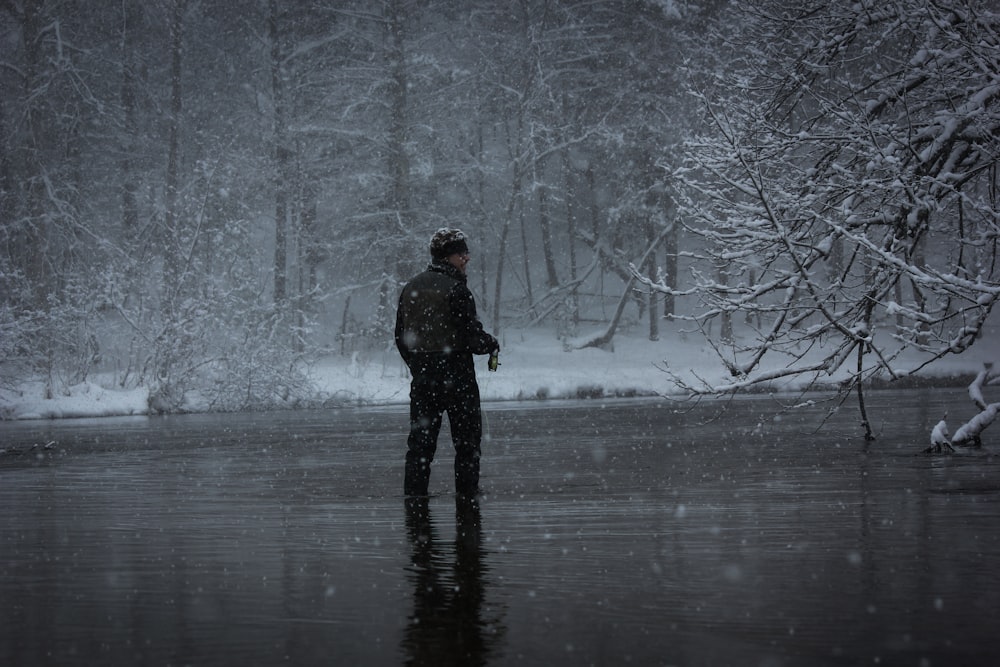 man standing on body of water during snow