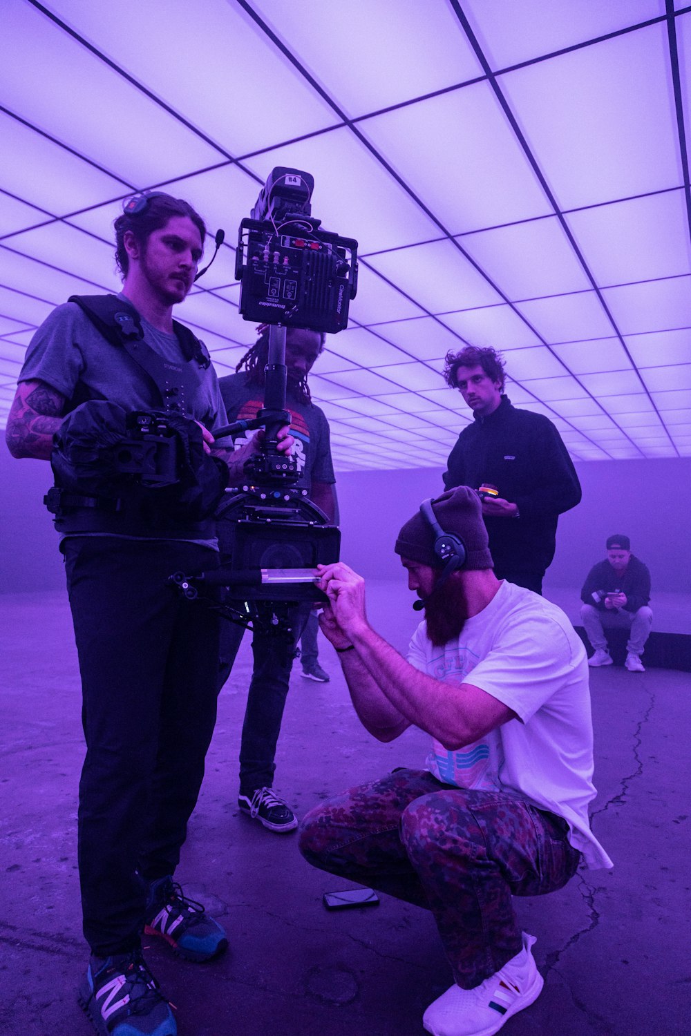 a group of men standing around a camera