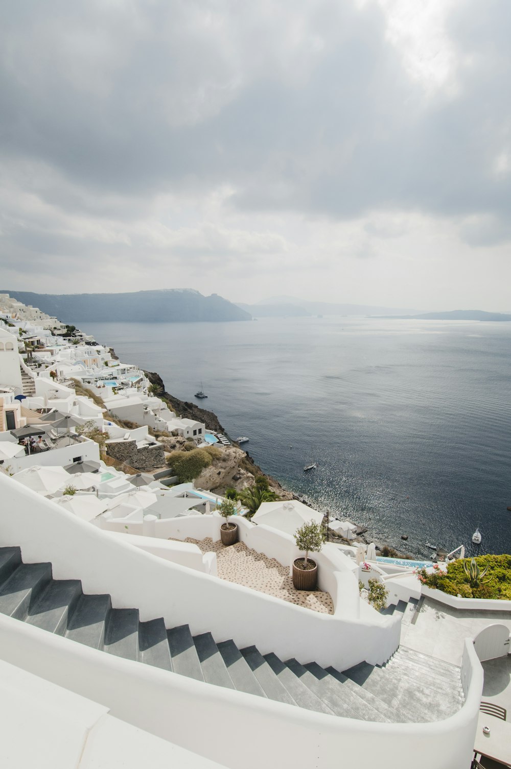white seaside resorts viewing sea and mountain under white and gray sky