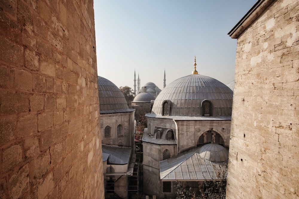 gray mosque between brick buildings