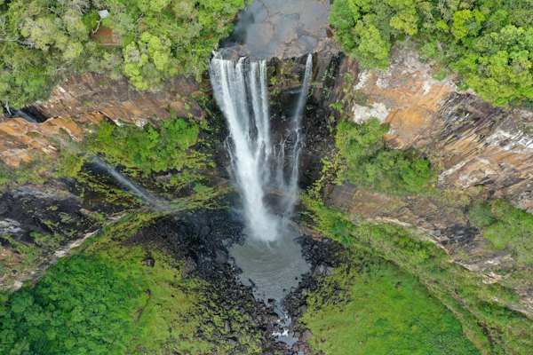 A waterfall dropping into a green gorge from the air — Chapada dos Veadeiros, Brazil