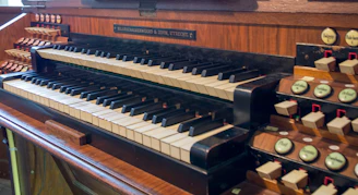 An old pipe organ with polished wooden keys and intricate carvings.