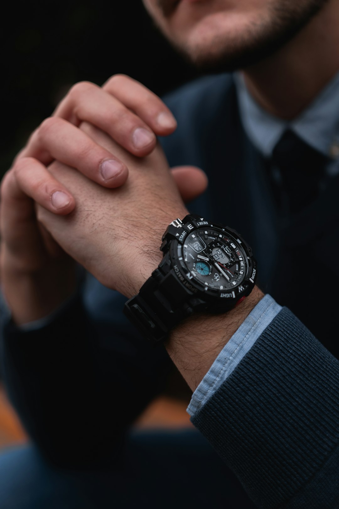 shallow focus photo of person wearing round black chronograph watch