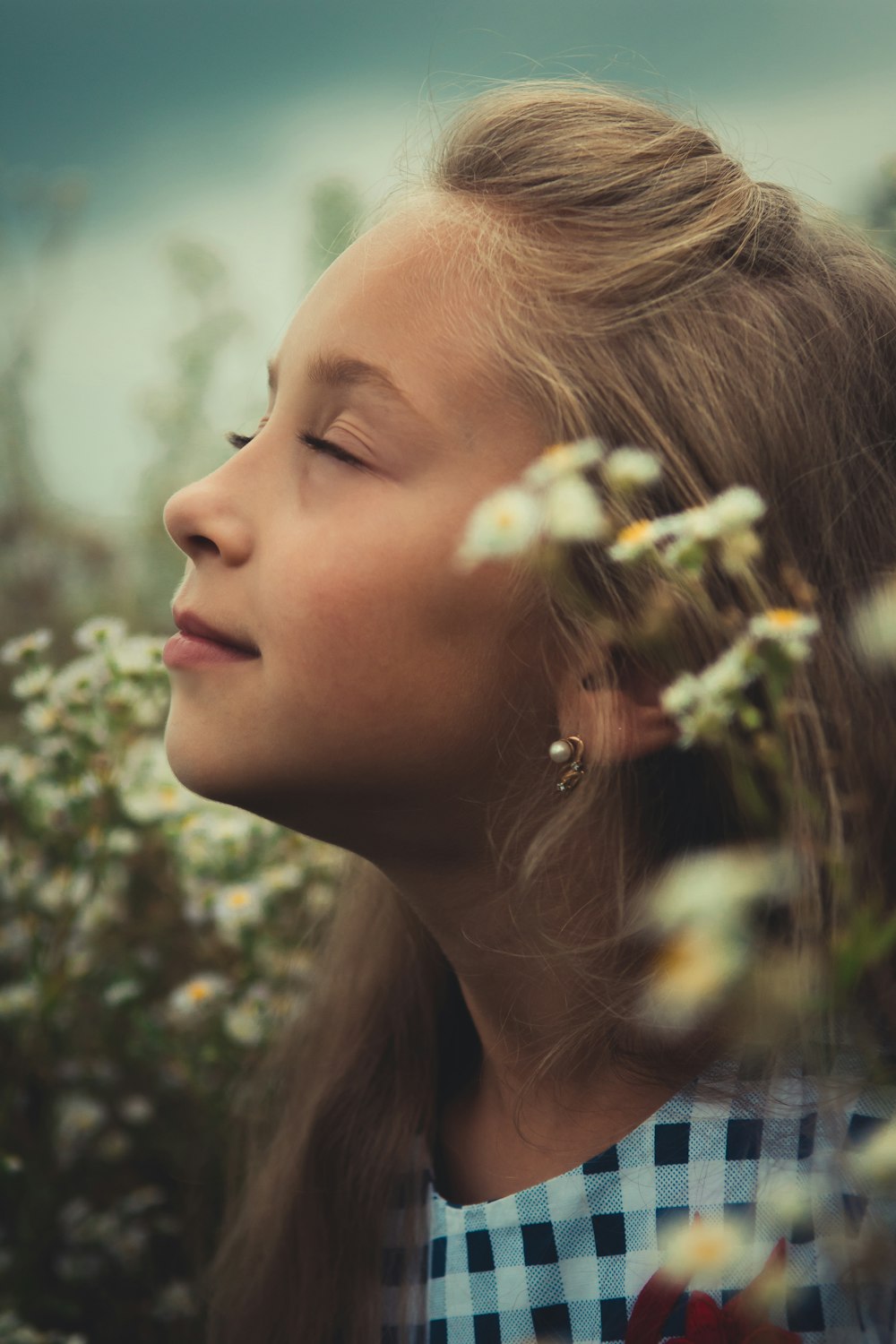 menina que está perto das flores brancas da pétala