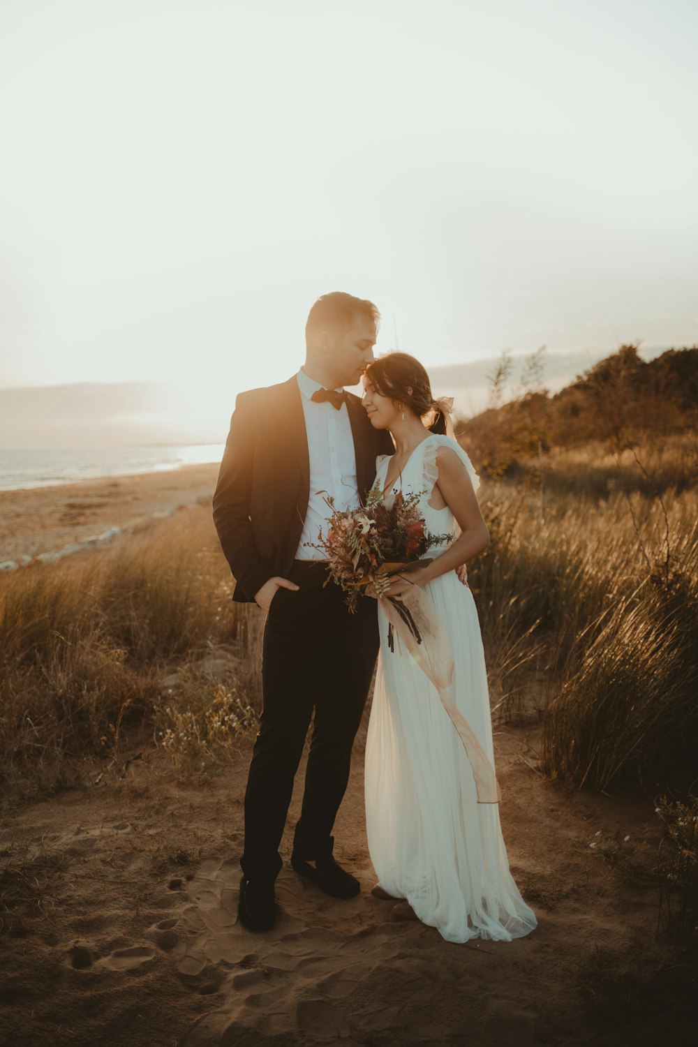 man in black formal suit beside white sleeveless dress