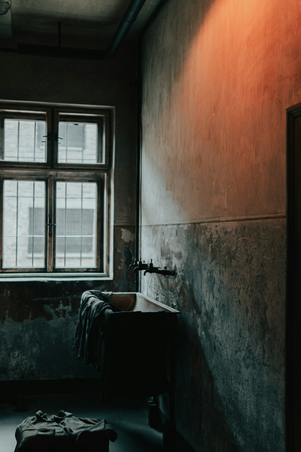 a dark room with a window and a suitcase on the floor
