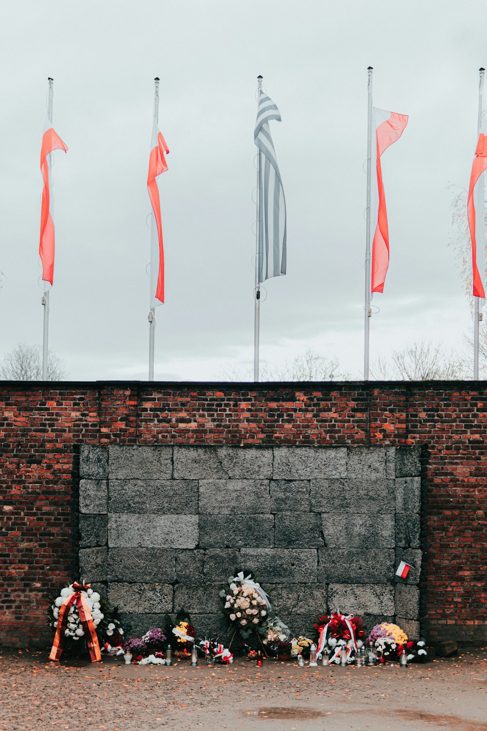 una pared de ladrillo con flores y banderas