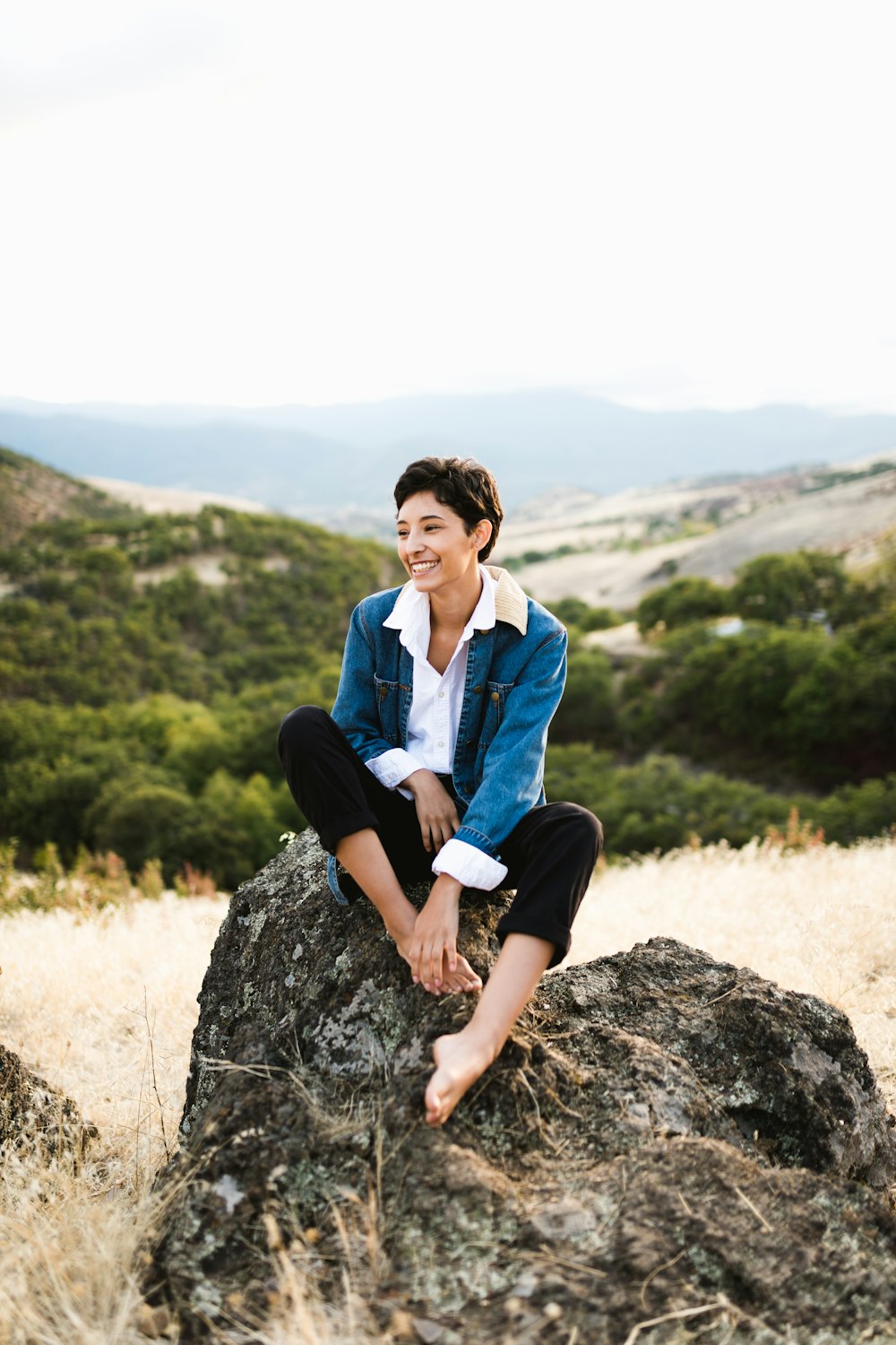 woman sitting on rock