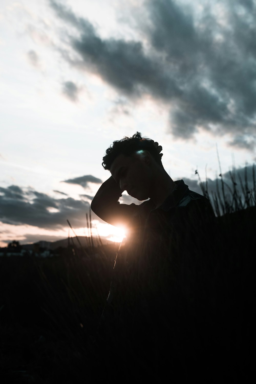 silhouette photography of man standing in grass during dawn