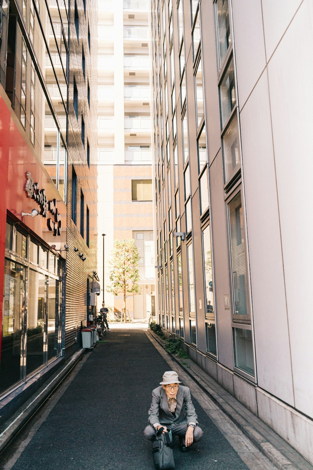 man sitting near white building