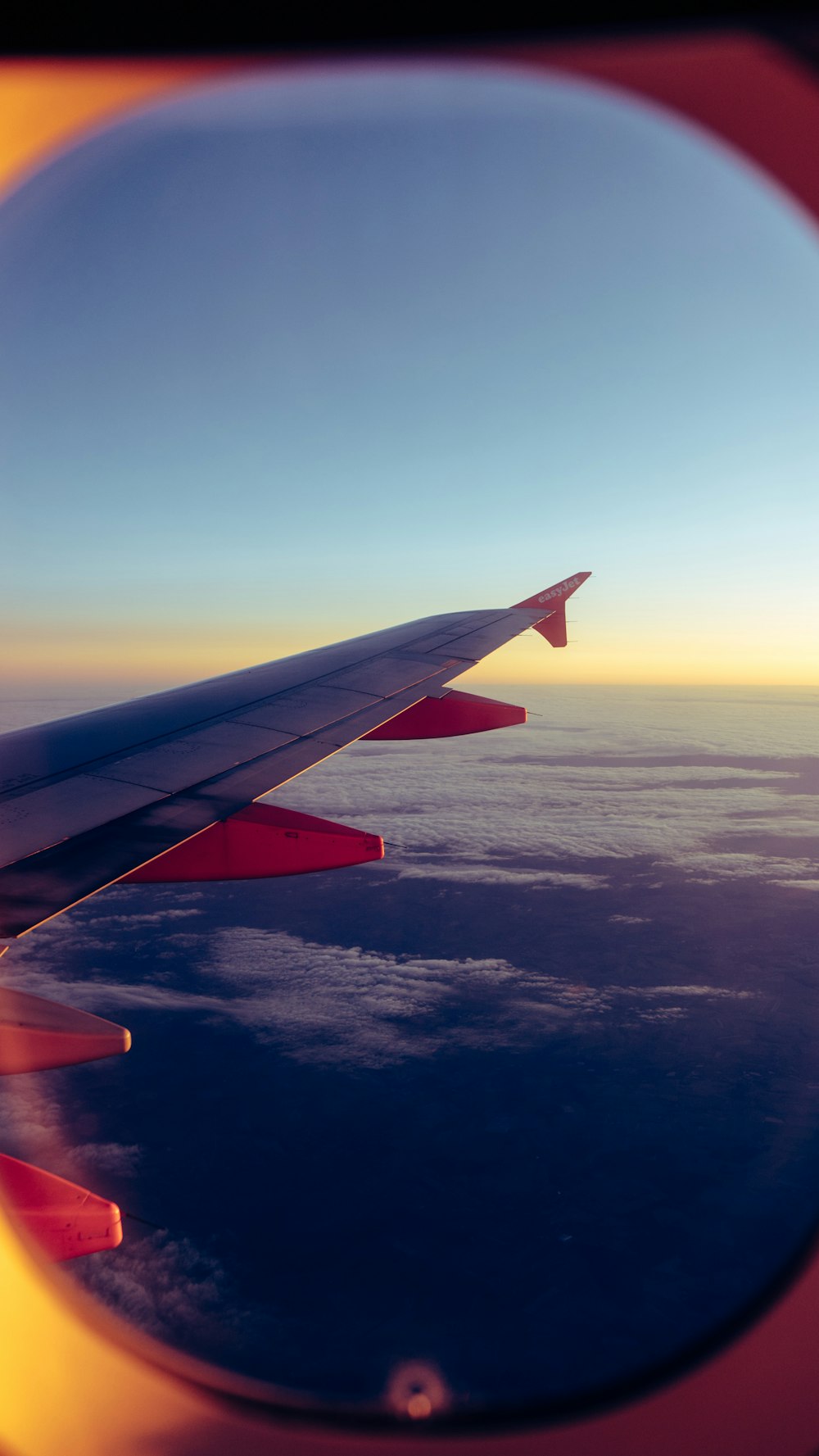 a view of the wing of an airplane as it flies over the ocean