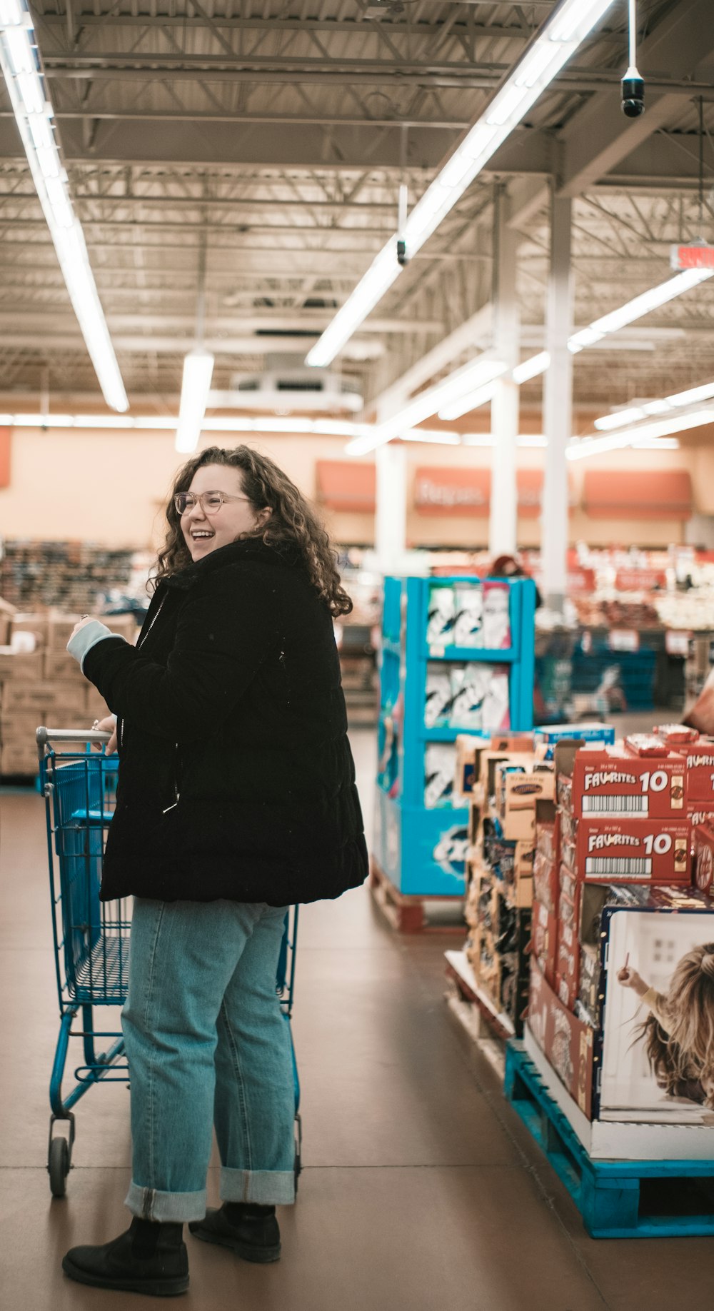 smiling woman wearing black jacket and blue jeans