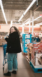 smiling woman wearing black jacket and blue jeans