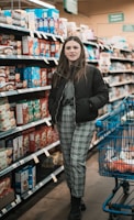 woman standing near shopping cart and groceries inside warehouse