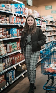 woman standing near shopping cart and groceries inside warehouse