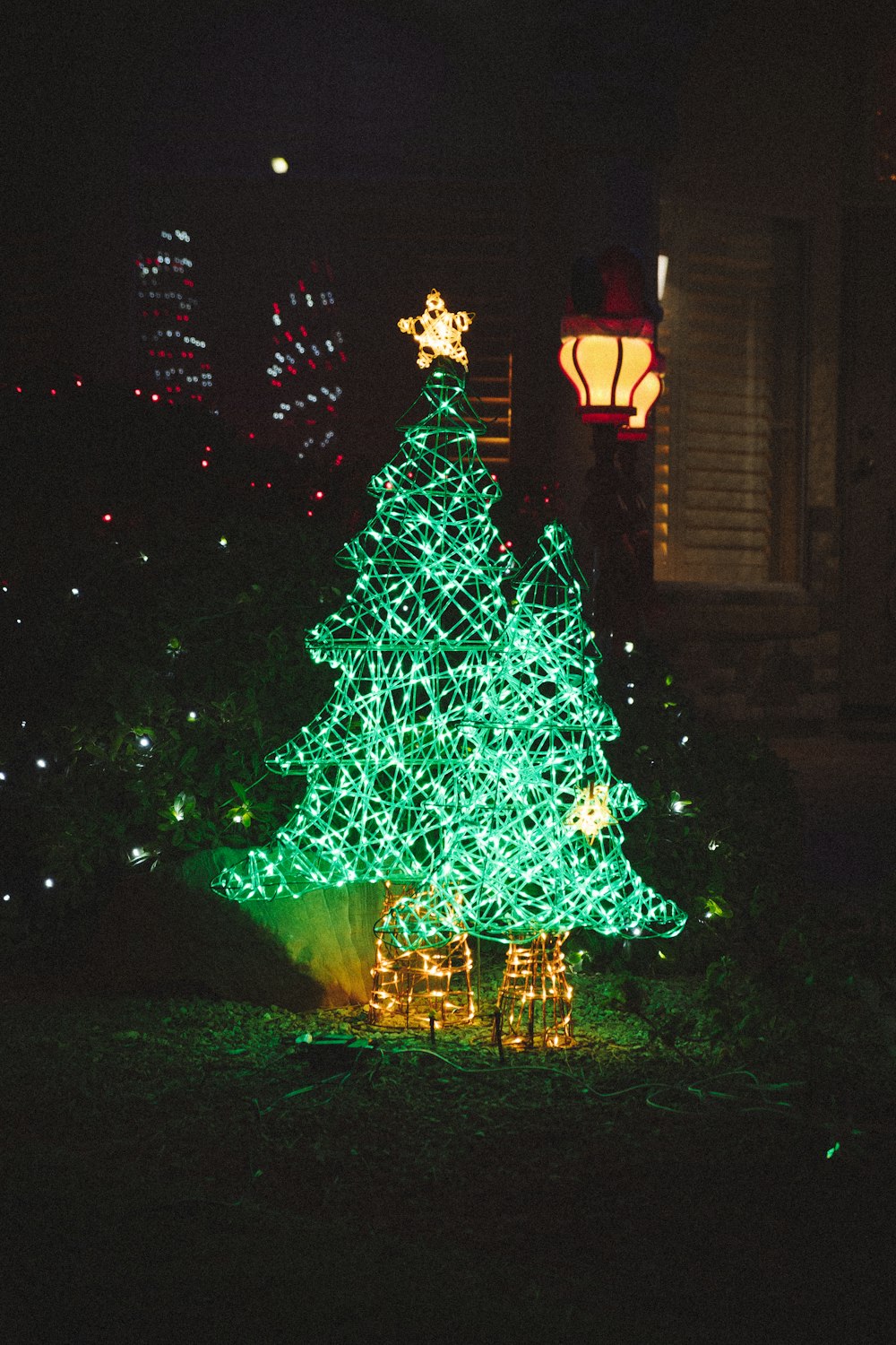 a lighted christmas tree in a yard at night