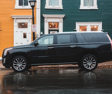 black Cadillac SUV beside road