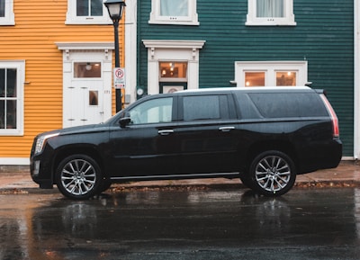 black Cadillac SUV beside road