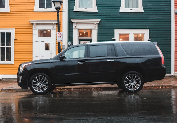 black Cadillac SUV beside road