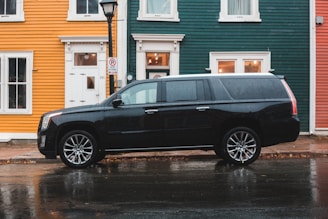 black Cadillac SUV beside road