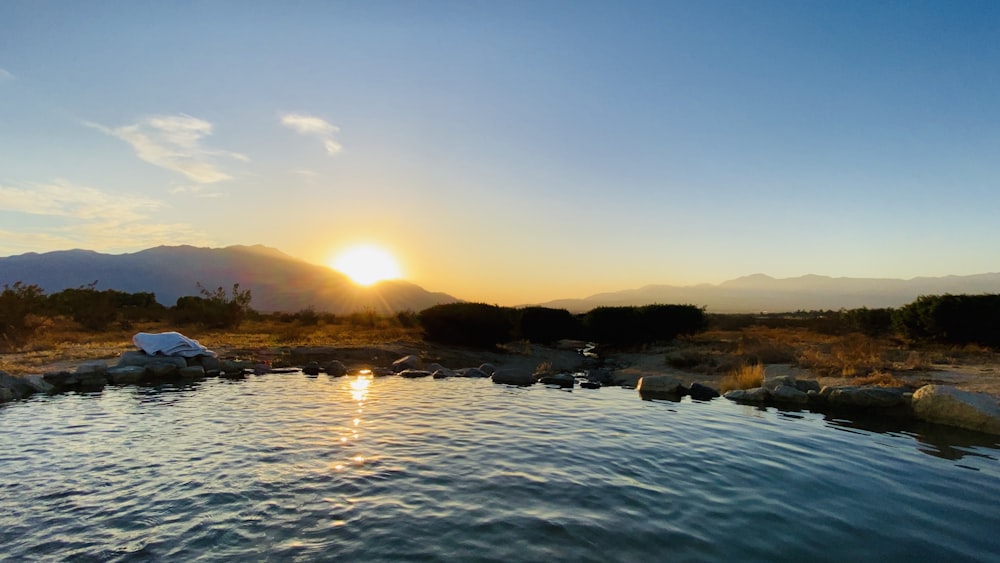 the sun is setting over a body of water