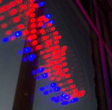 A vibrant array of red and blue LED lights forms an arrow shape on a reflective surface.