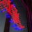 A vibrant array of red and blue LED lights forms an arrow shape on a reflective surface.