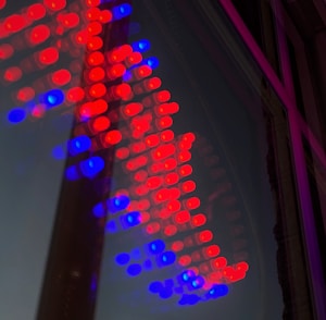 A vibrant array of red and blue LED lights forms an arrow shape on a reflective surface.