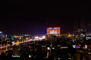 A wall-mounted ultra-thin TV showing a colorful cityscape at night.