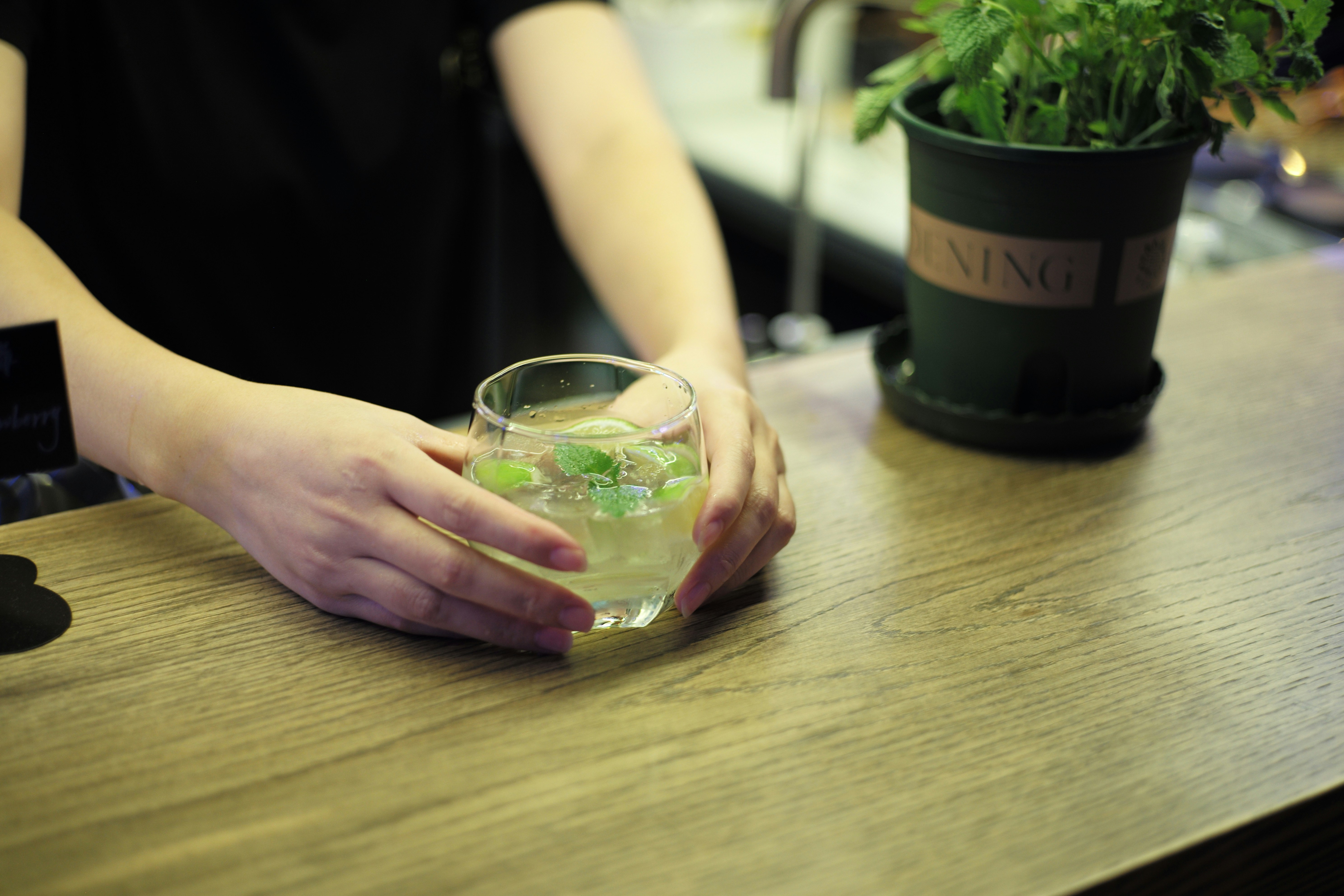 person holding clear glass cup filled with green liquid