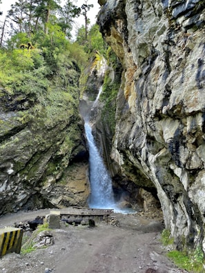 A picturesque forest path leading to a hidden waterfall.