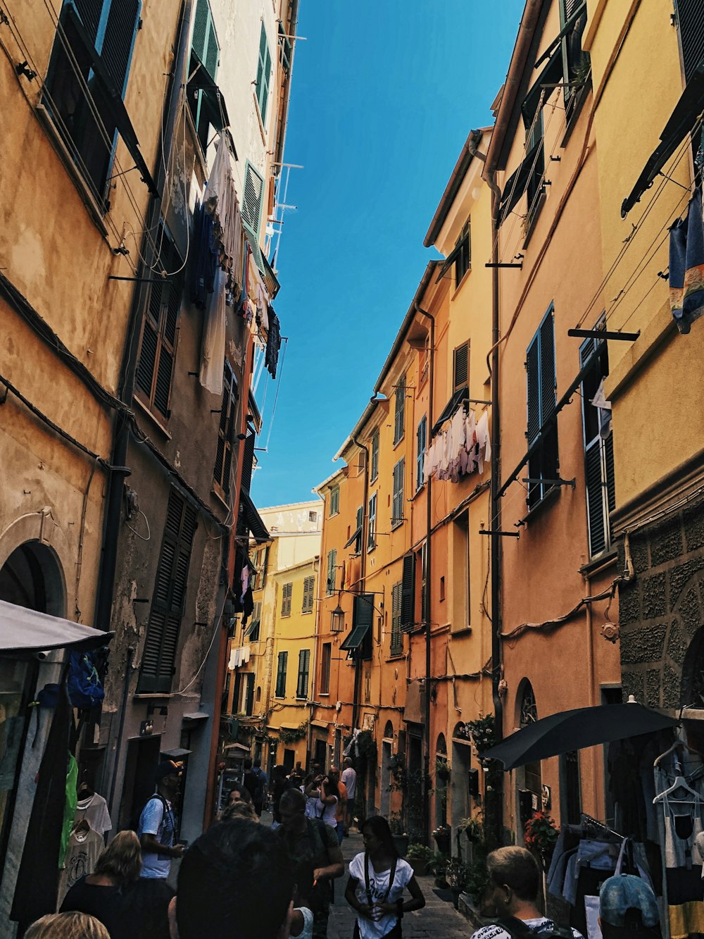 people walking along narrow road between buildings