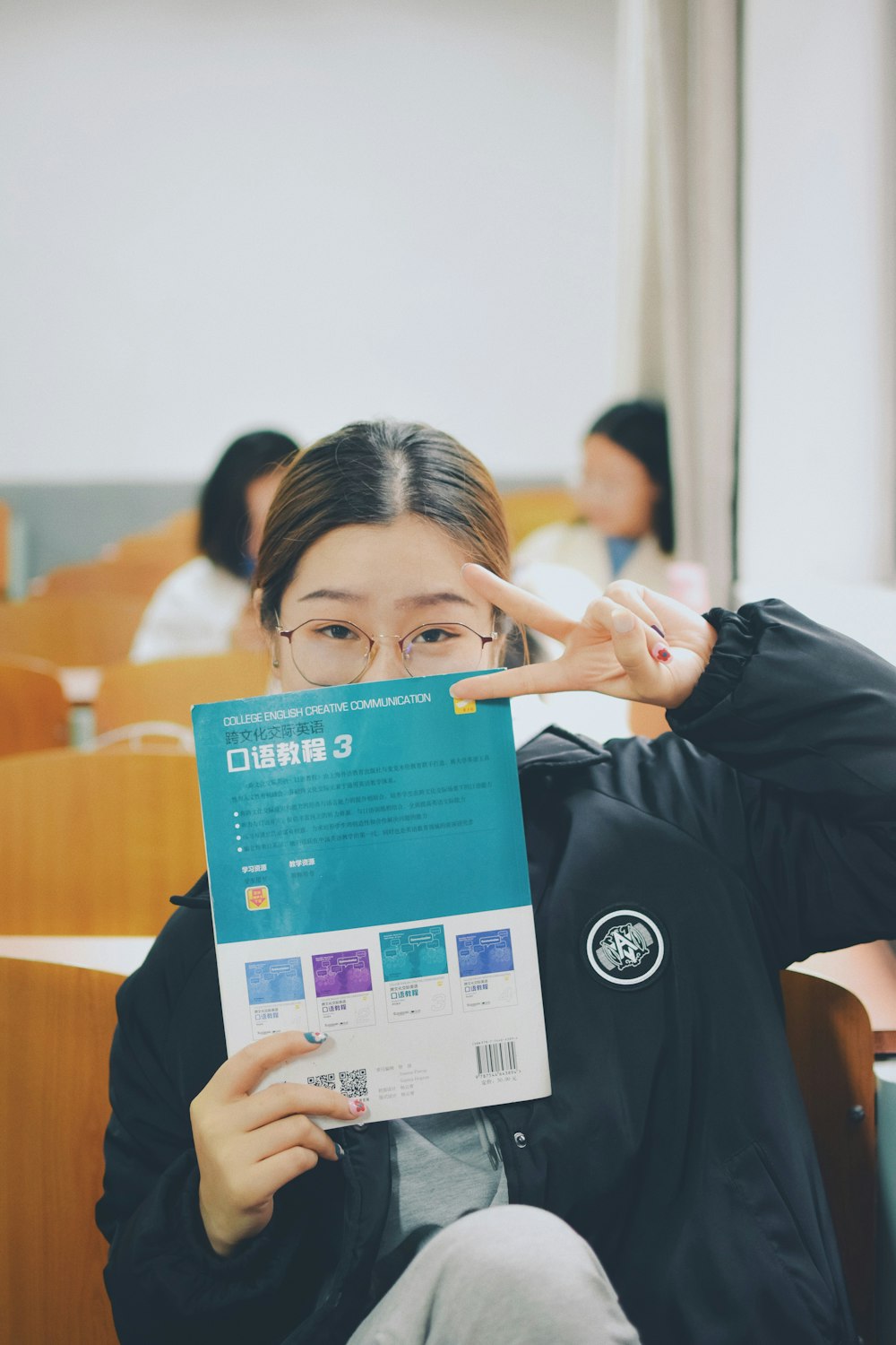 woman covering face with a book