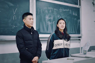 man and woman standing in front of blackboard