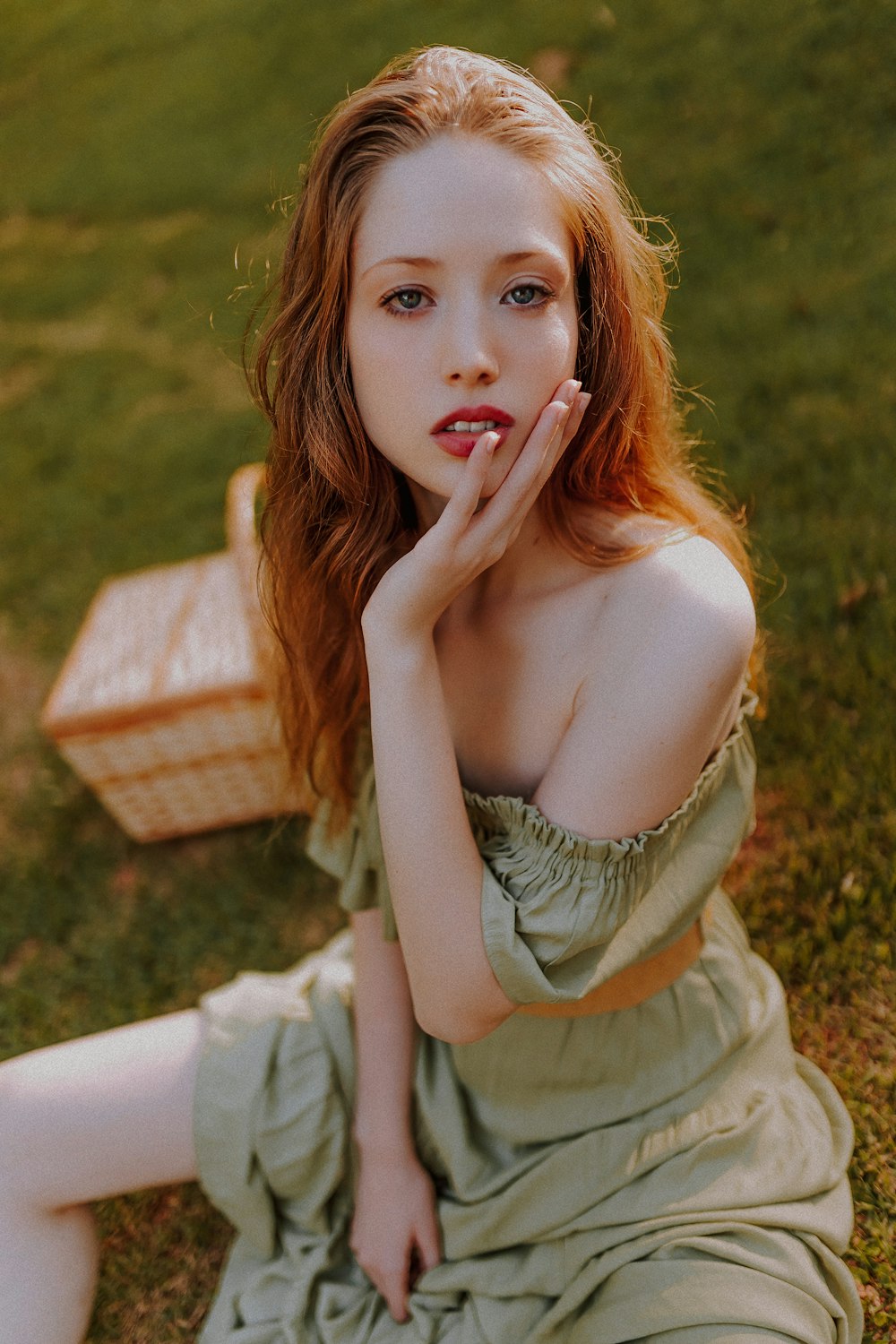 femme assise sur l’herbe à côté d’un panier de pique-