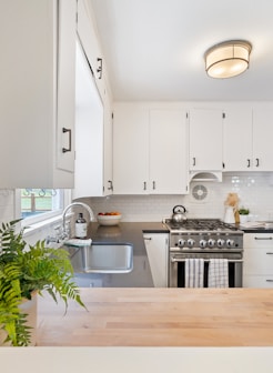 white wooden kitchen cupboards and gray gas stove