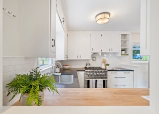 white wooden kitchen cupboards and gray gas stove